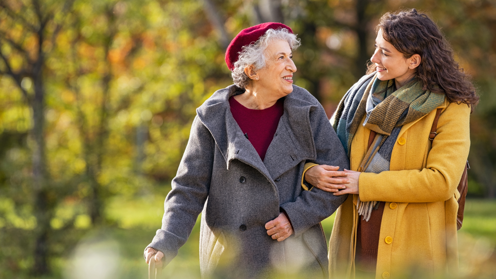 Two women walking in a park.  One older than the other.