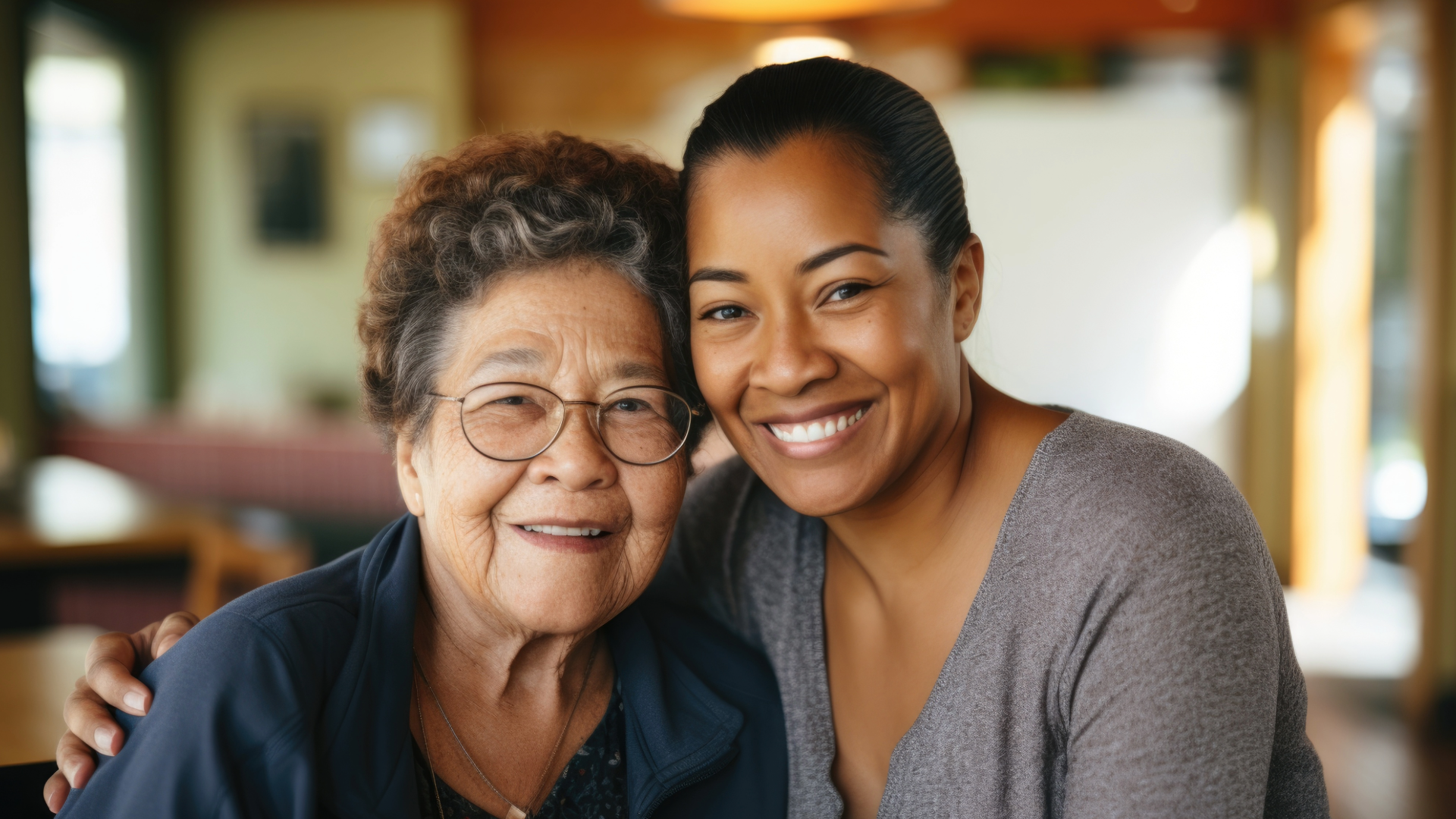 Two women smiling with their heads together.